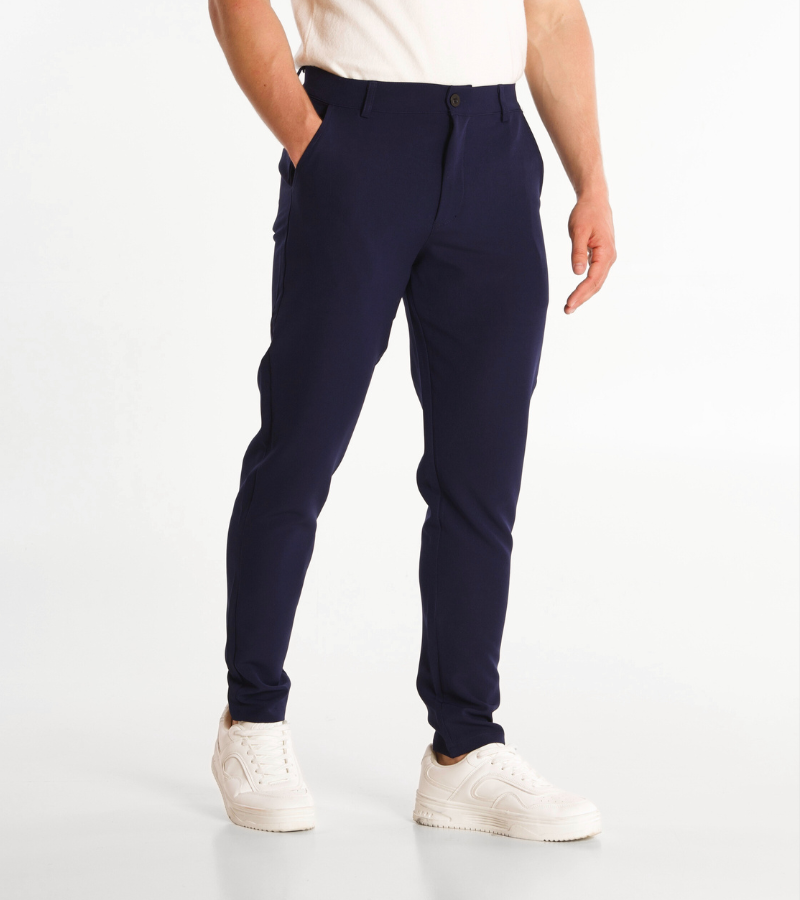 Person wearing navy pants and white shoes on a white background