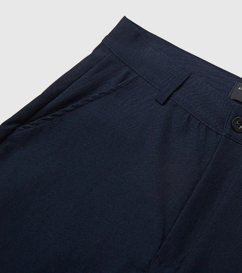 Close-up of navy blue casual pants waistband with belt loop, button, and side pocket