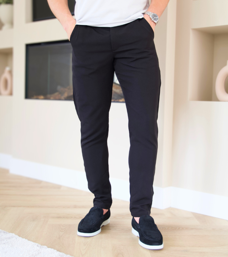 Person wearing black pants and a white shirt in a room with a fireplace.
