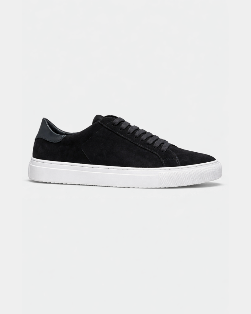 Minimalist luxury black suede trainers with tonal laces, sleek leather heel tab, and premium white rubber cupsole.
