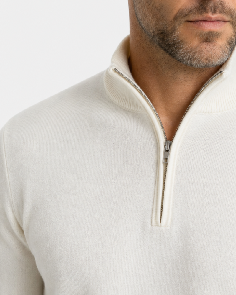 Close-up of a person wearing a cream-colored quarter-zip sweater against a white background #color_beige