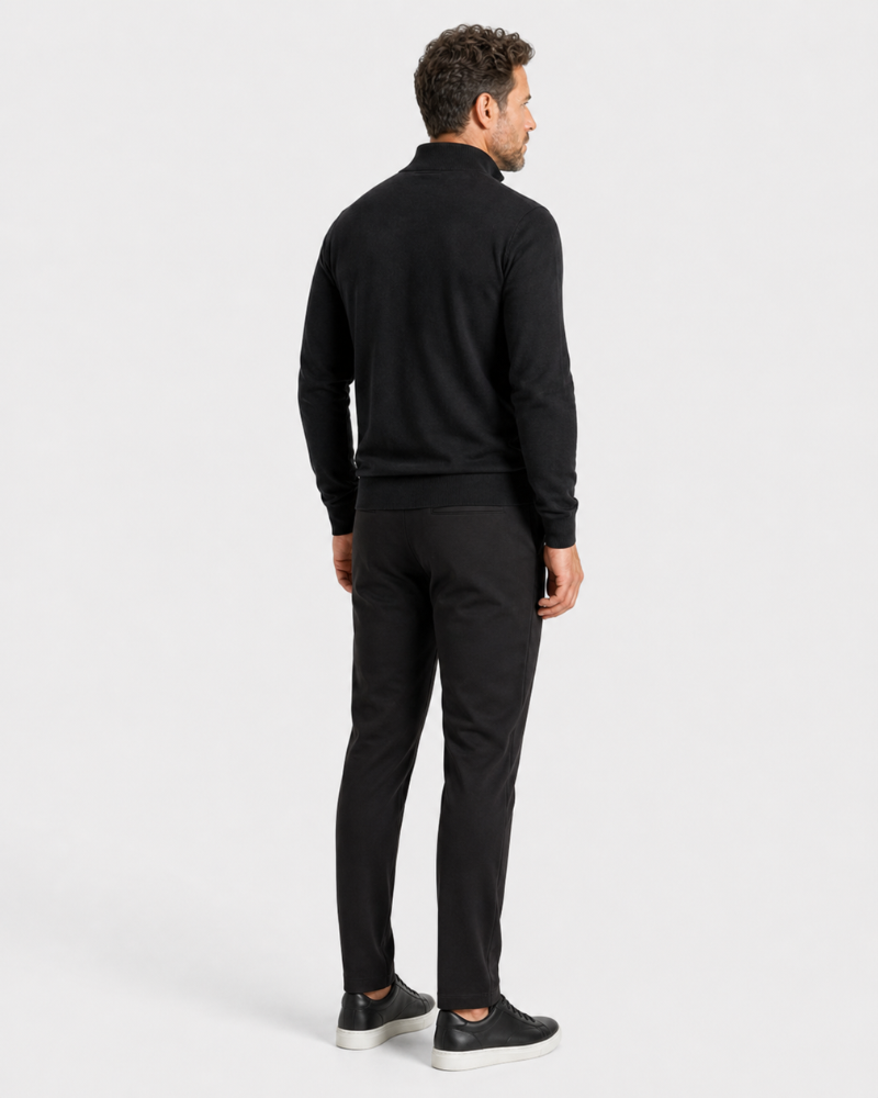 Man wearing a By Alden black quarter-zip sweater and black pants on a white background #color_black