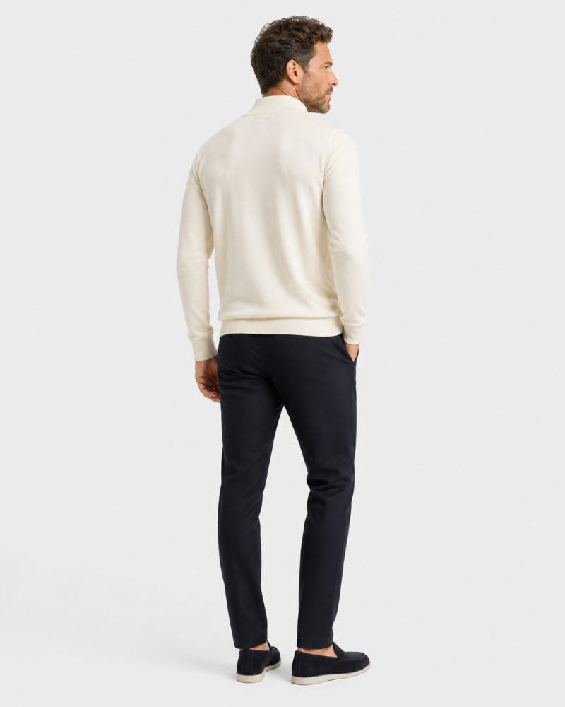 Man wearing a By Alden cream sweater and black pants on a white background #color_beige