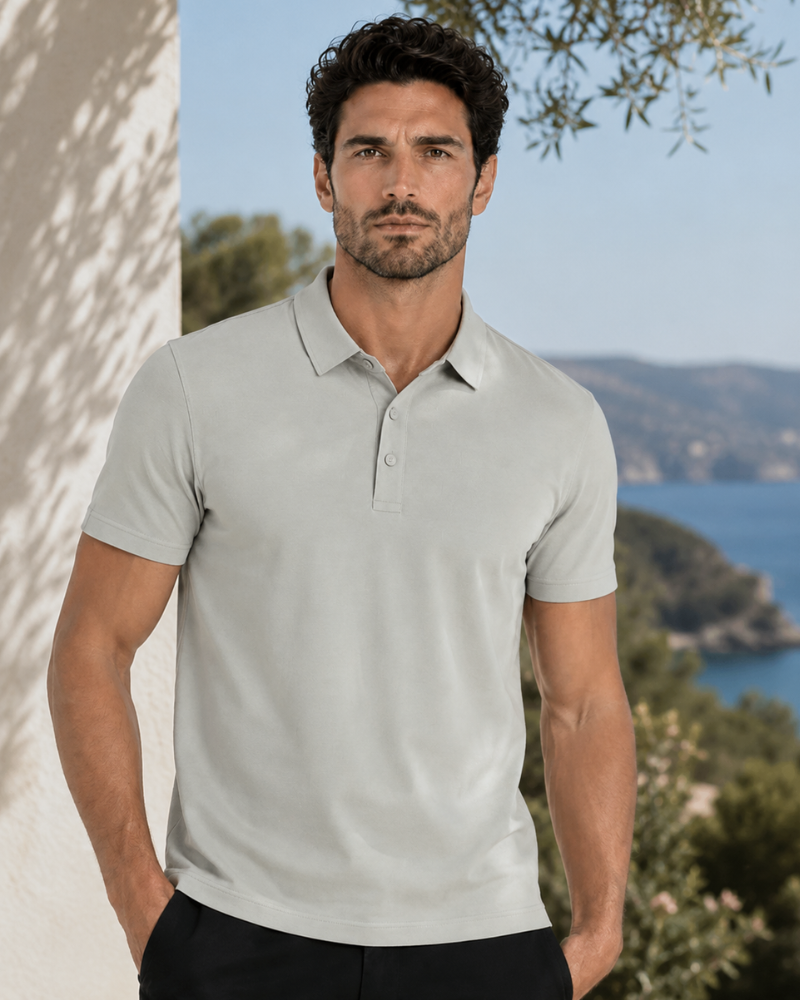 By Alden light gray knit polo shirt on male model, front view, upper body, outdoor blue sea background. #color_deep stone