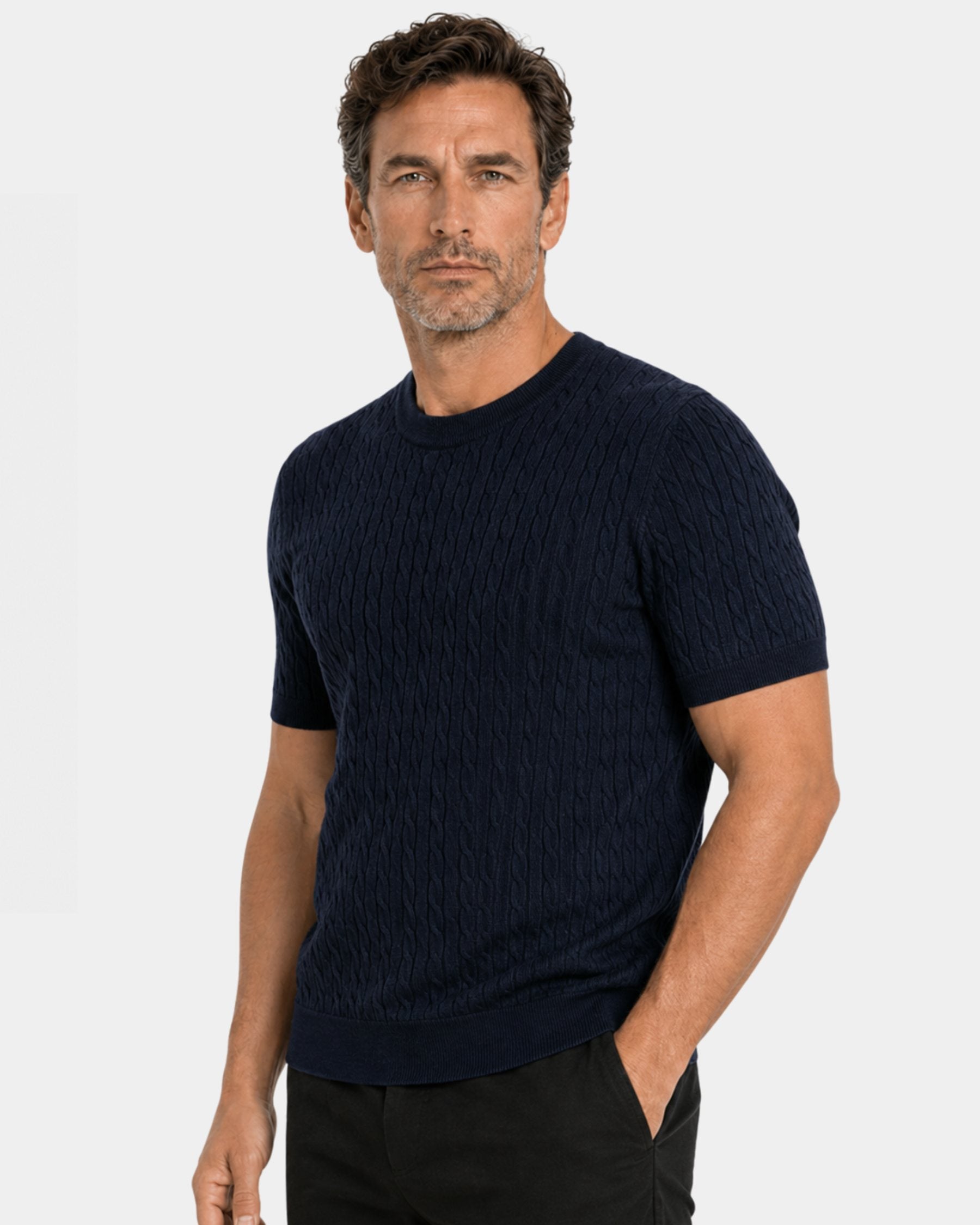 By Alden navy cable-knit short-sleeve sweater on male model, three-quarter view upper body, light gray background #color_navy