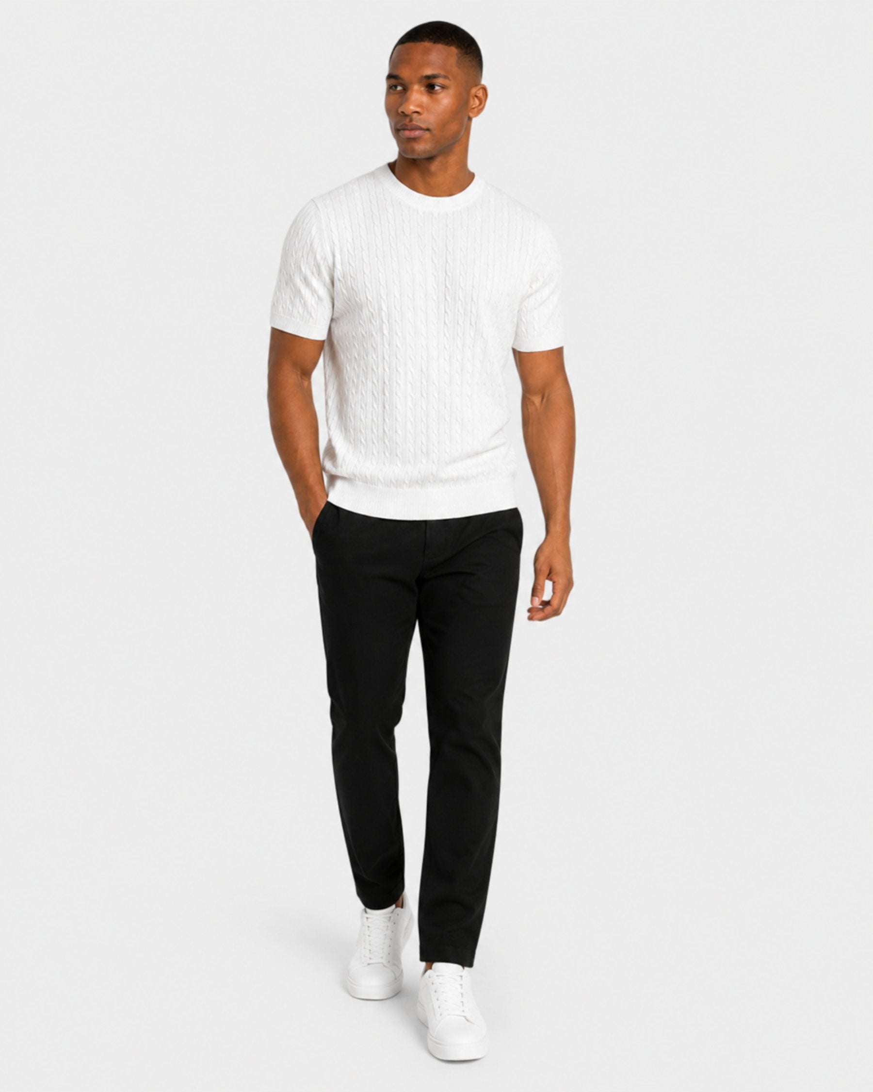 By Alden white cable-knit short-sleeve sweater on male model, three-quarter view full body, light gray background #color_white
