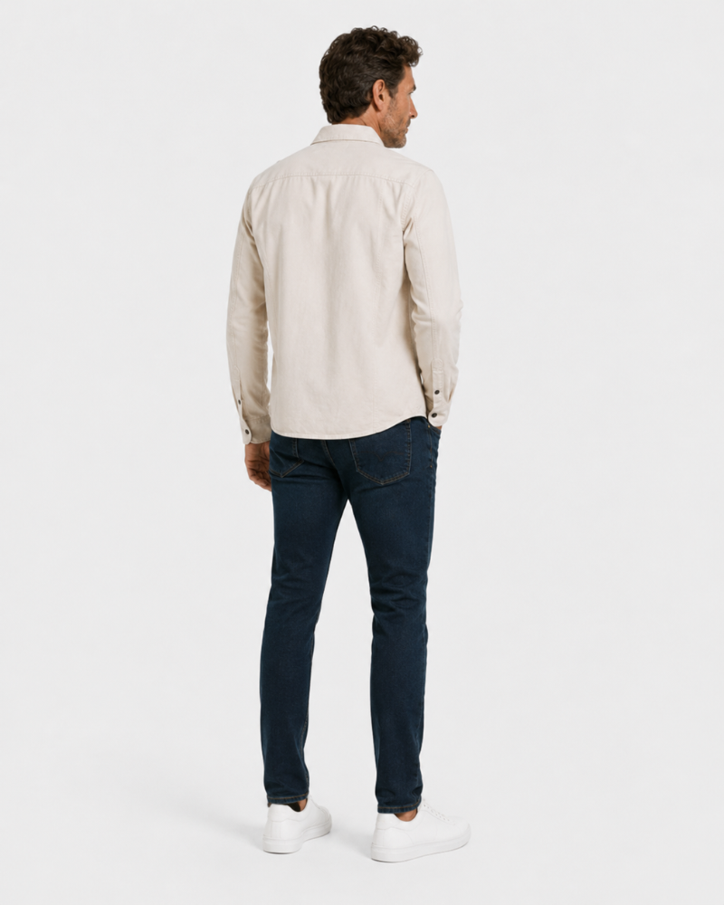 Man wearing a By Alden stone shirt and blue jeans on a white background #color_stone