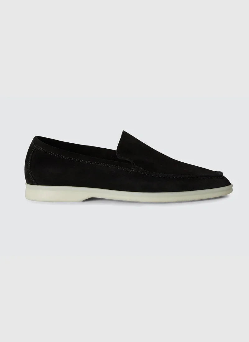 Black suede men's yacht loafer with white sole on light gray background