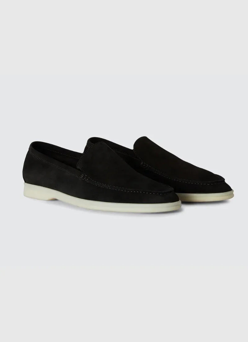 Pair of black suede Alden Ash yacht loafers with white rubber soles on a light background