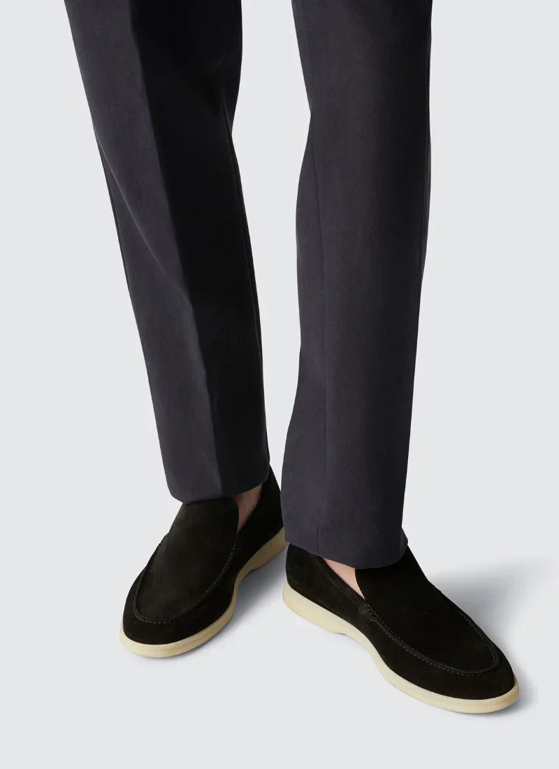 Men's black suede Alden Ash Yacht Loafers with white sole worn with dark pants on light background