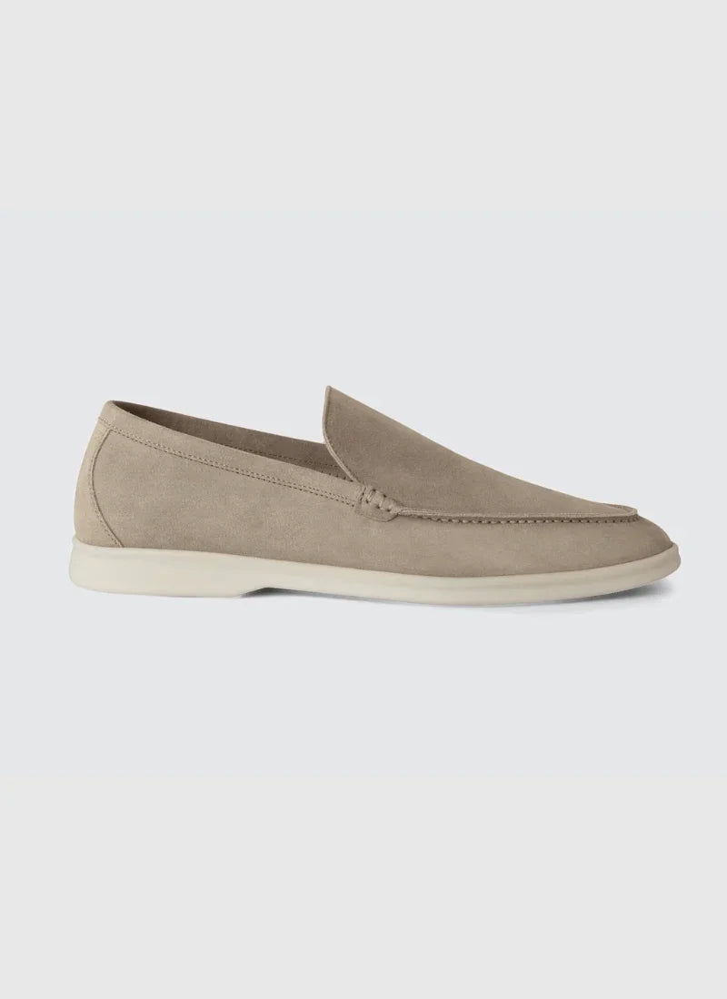 Beige suede men's loafer with white sole on light gray background