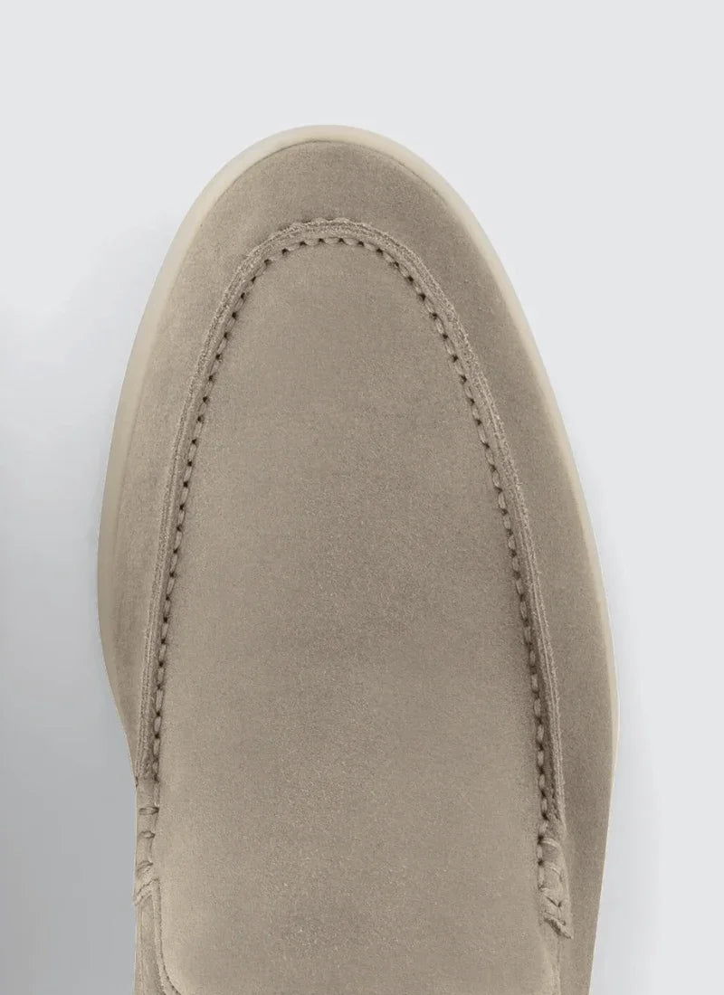 Close-up of a beige suede men's loafer showing fine stitching and smooth texture