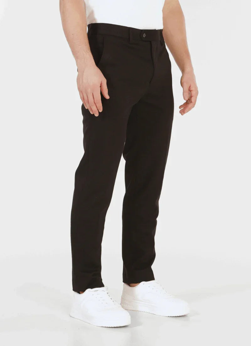 Men's black classic wool mix trousers styled with white sneakers on a white background