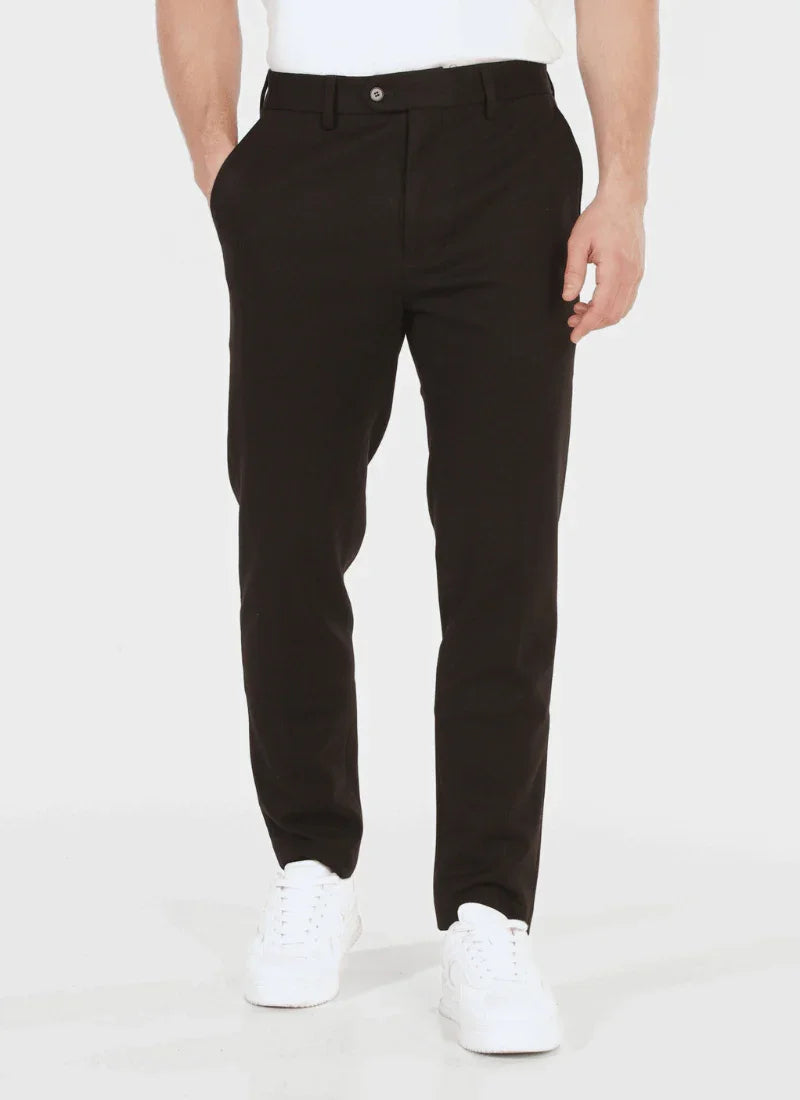 Men's black classic wool blend trousers styled with white sneakers and a casual white shirt