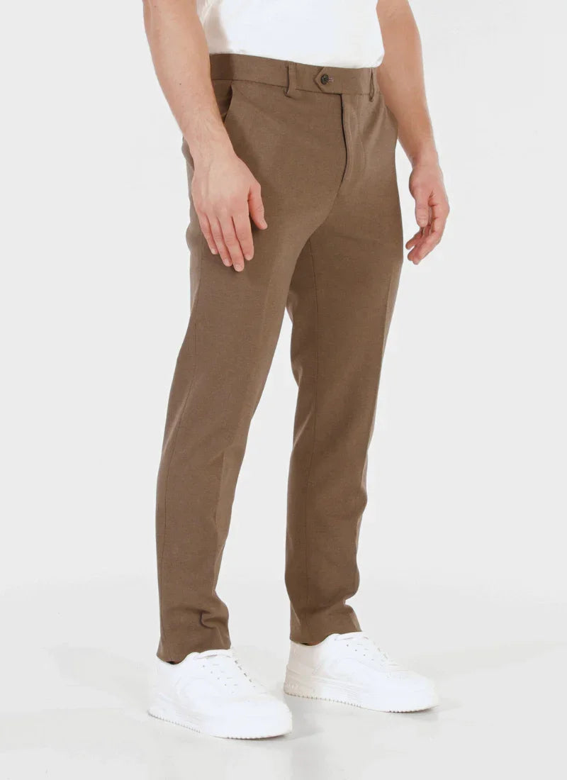 Man wearing slim-fit brown wool blend trousers with side pockets and white sneakers