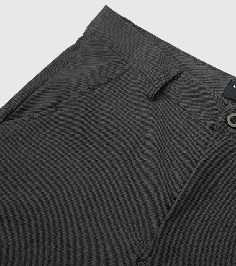 Close-up of dark gray pants pocket and waistband with belt loop and button detail
