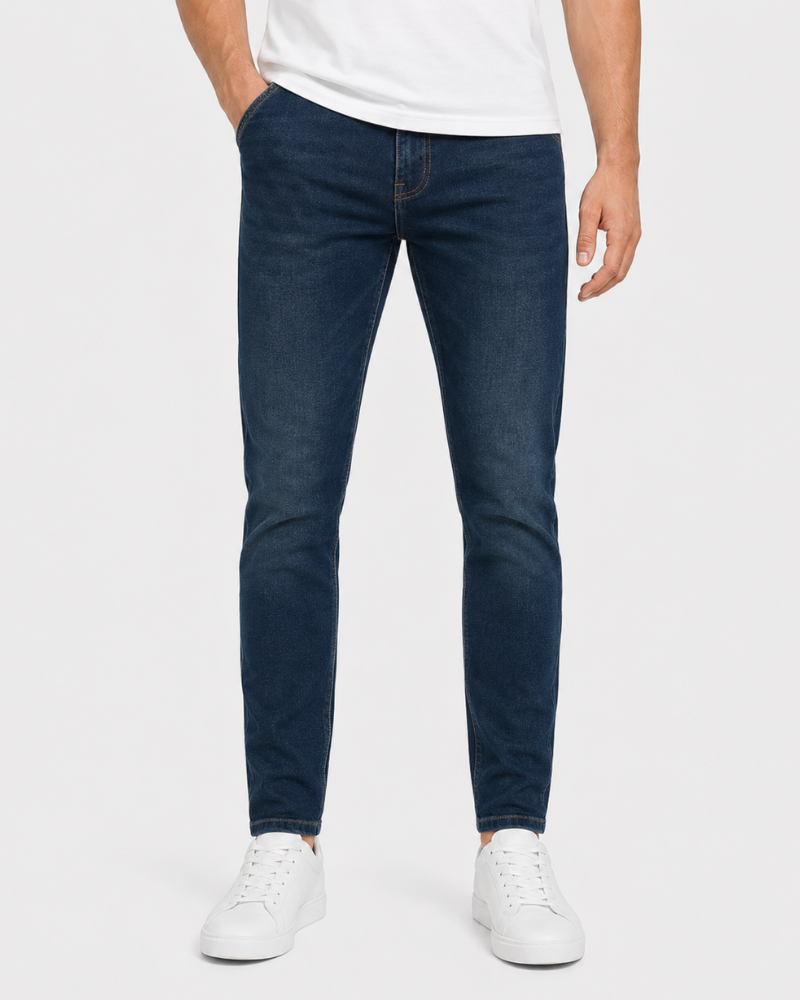 Person wearing dark blue jeans and white sneakers on a white background #Color_navy