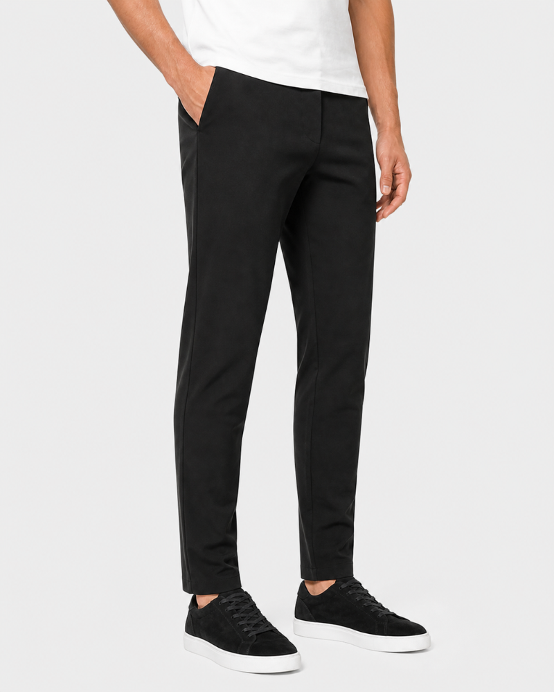 Person wearing By Alden black pants and white sneakers on a white background #Color_black