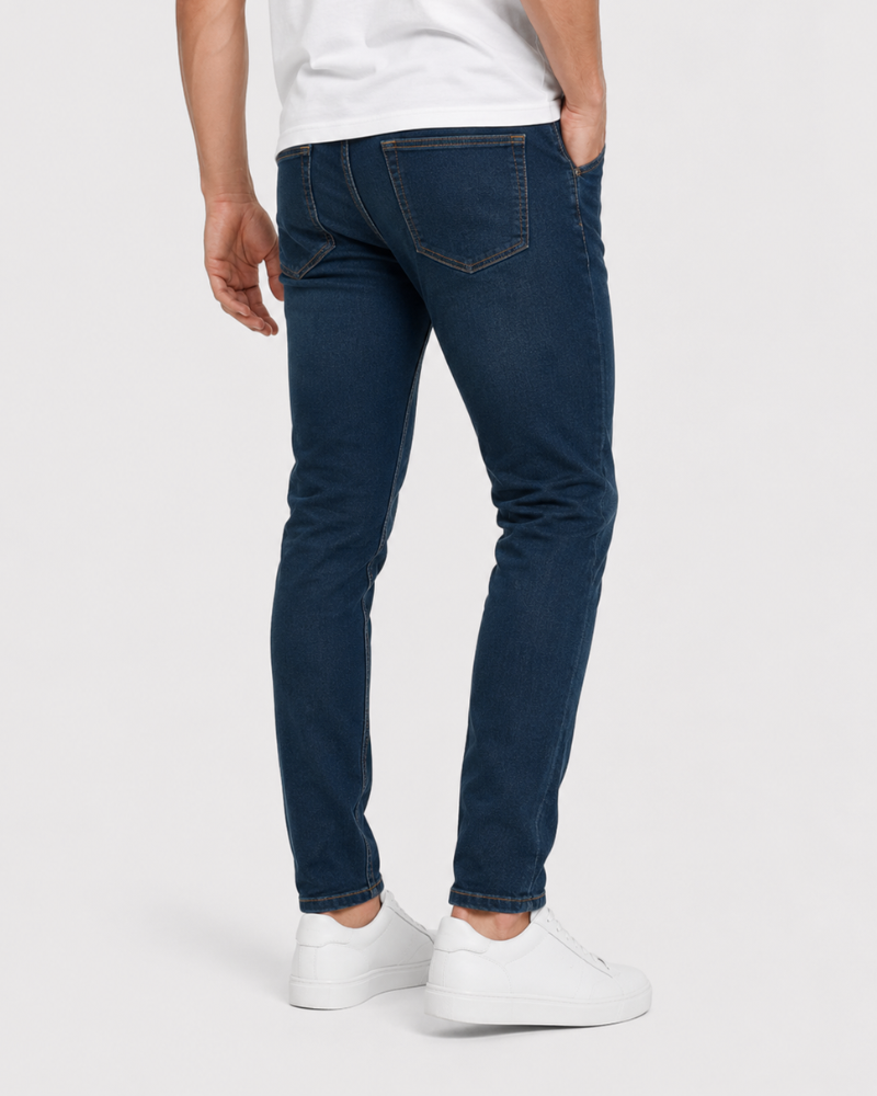 Person wearing dark blue jeans and white sneakers on a white background #Color_navy