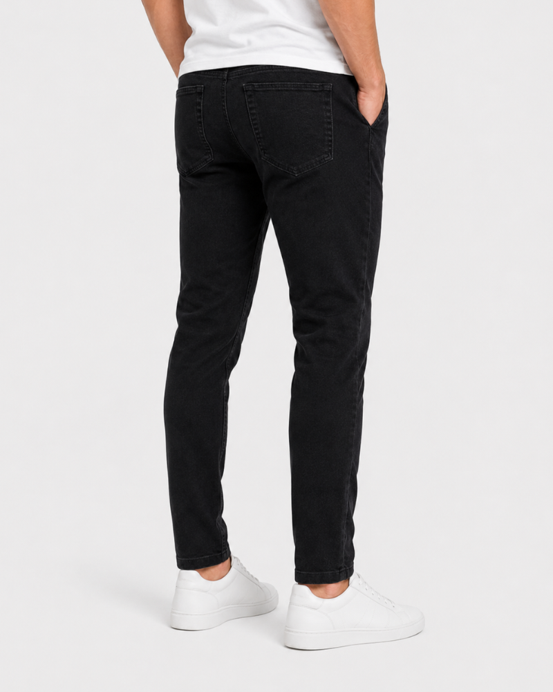 Person wearing black jeans and white shoes on a white background #Color_black