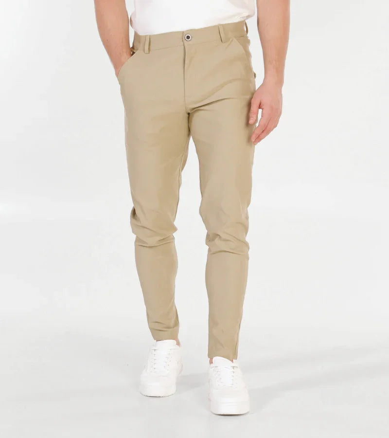 man wearing slim fit khaki chinos with white sneakers on white background