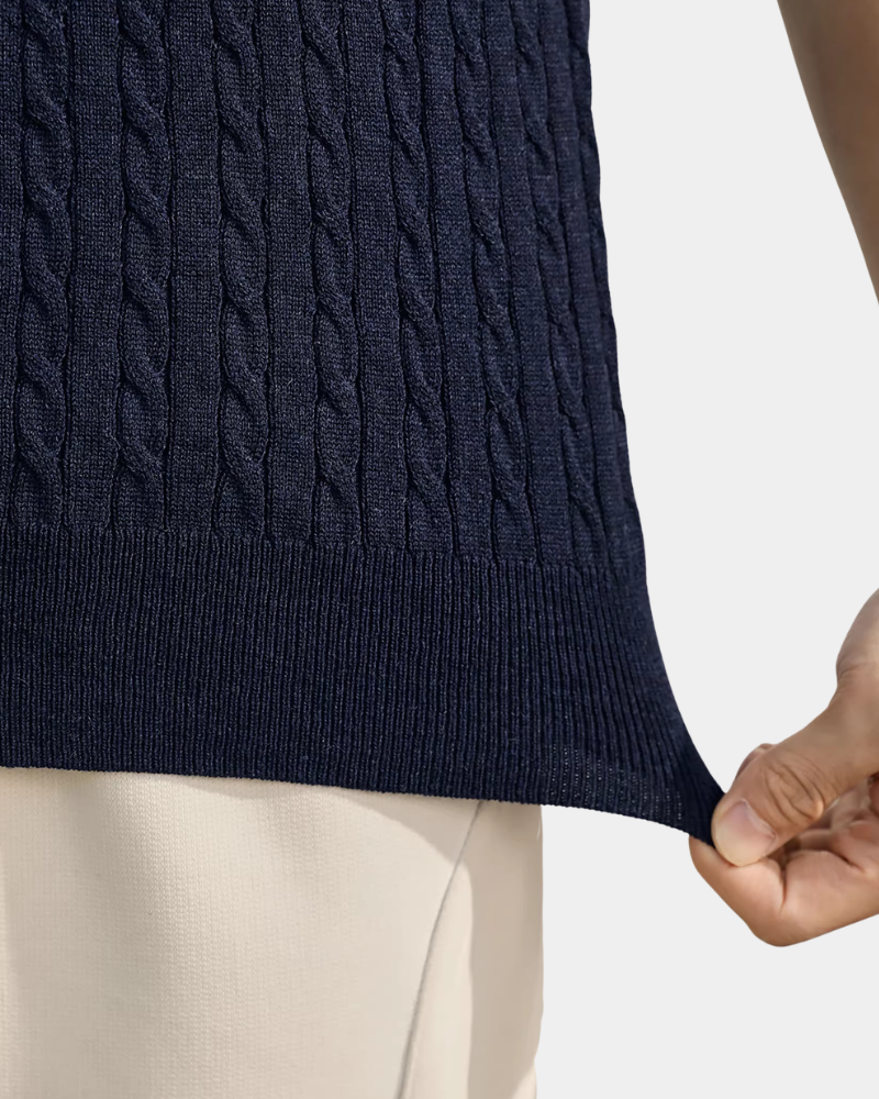 Close-up of a navy wool-blend cable knit t-shirt hem. Minimalist luxury ribbed waistband with premium elasticated fit.
