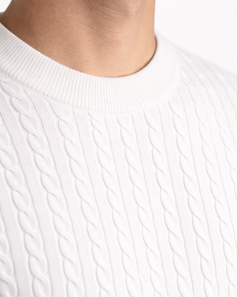 Minimalist luxury white cable knit t-shirt in premium cotton. Detail of the refined texture and ribbed neckline.