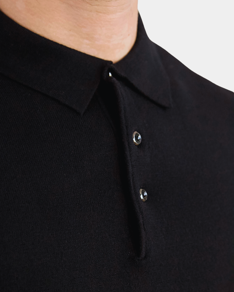 Close-up of By Alden luxury black merino wool knit. Minimalist texture with a refined placket and polished button details. #color_black