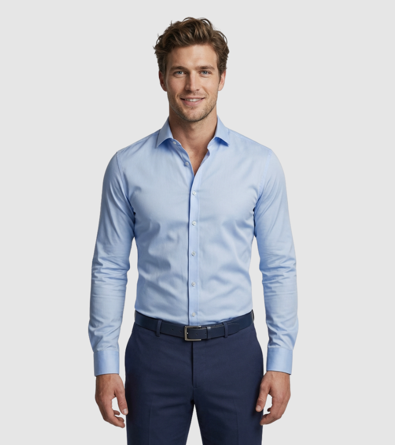 Man wearing a light blue dress shirt and dark blue pants on a plain background