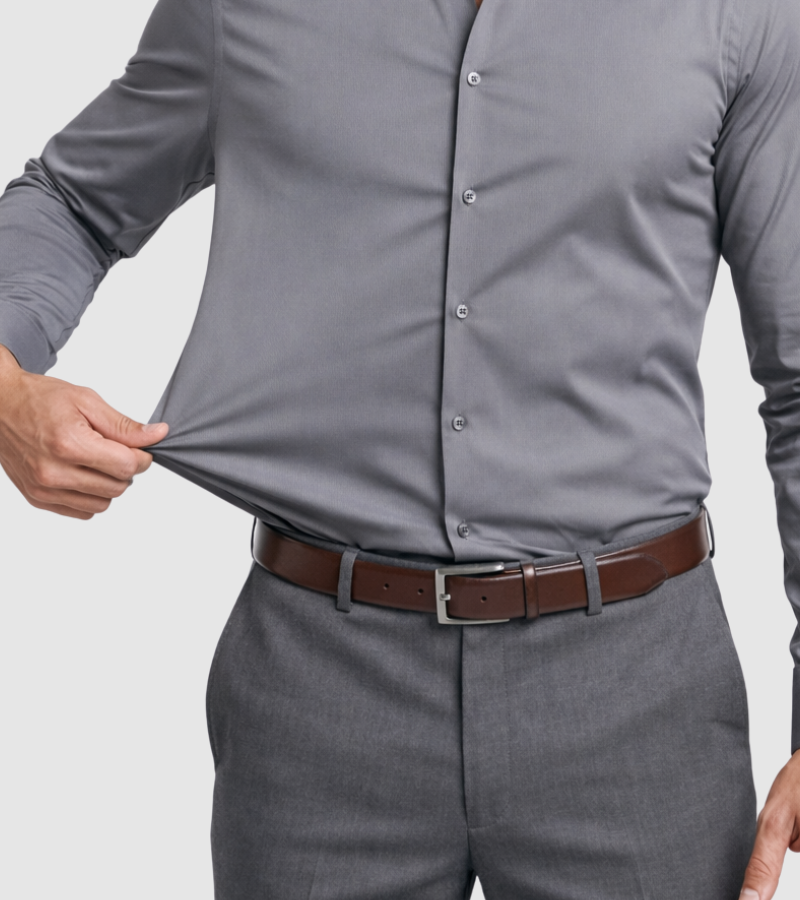 Person wearing a gray dress shirt and gray pants with a brown belt on a light gray background