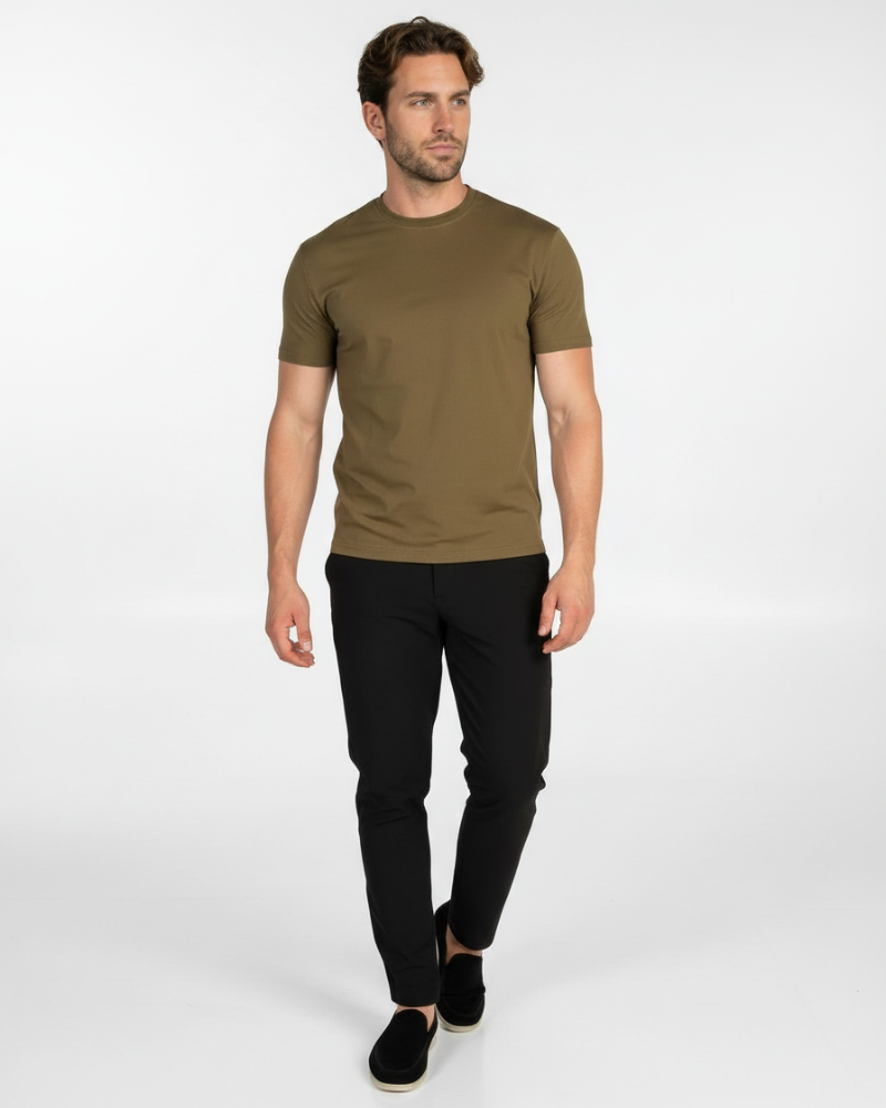 Model wearing a luxury olive Smart Fit T-shirt in motion, styled with black trousers for a clean, minimalist look.