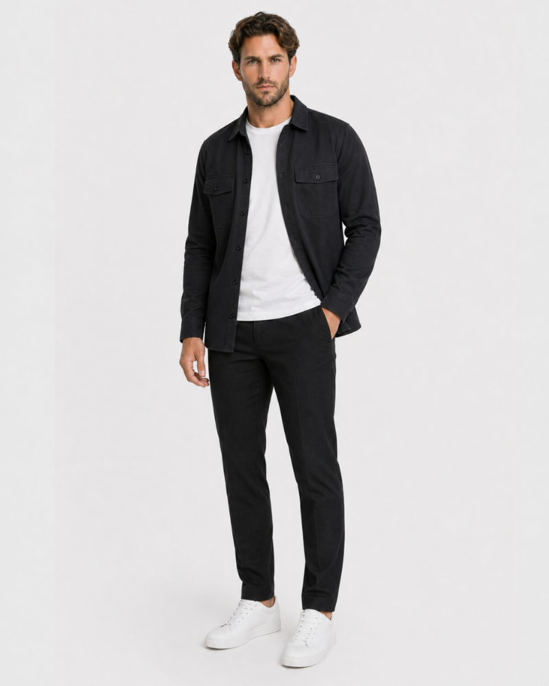 Man wearing a By Alden black shirt, white t-shirt, black pants, and white sneakers on a white background #color_black