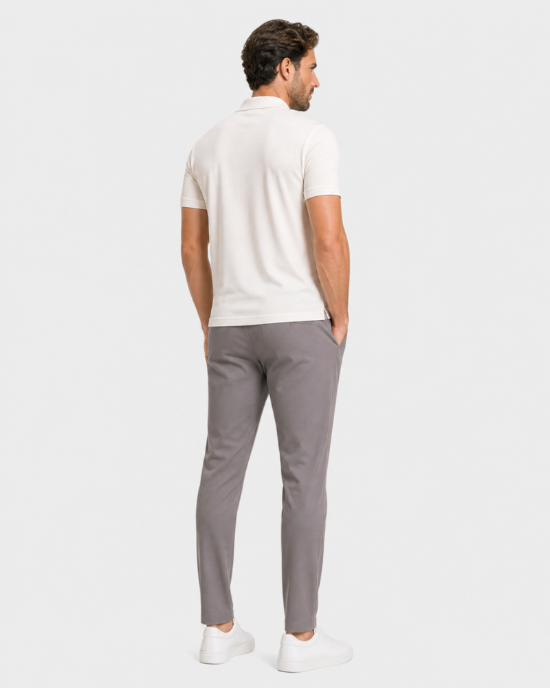 Man wearing a By Alden white polo shirt and gray pants on a white background #Color_gray