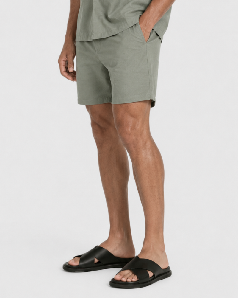 By Alden Sage Green Linen Shorts worn by a male model, cropped front angle view, light grey background #Color_olive green