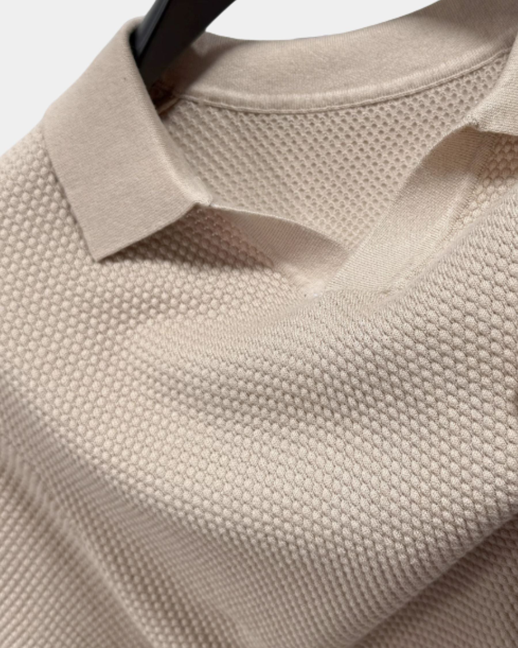 By Alden Stone open-collar knit polo shirt collar and fabric texture detail, hanger, close-up, light gray background. #color_stone
