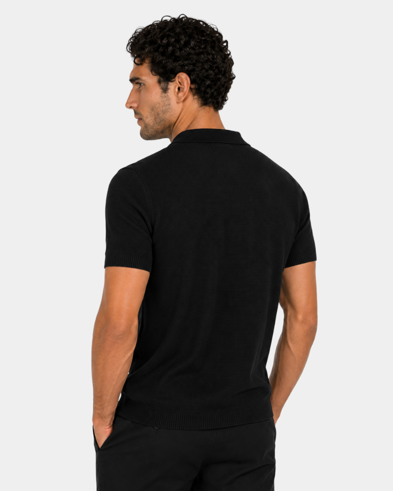 By Alden black open-collar knit polo shirt on male model, back view, upper body, light gray background. #color_black