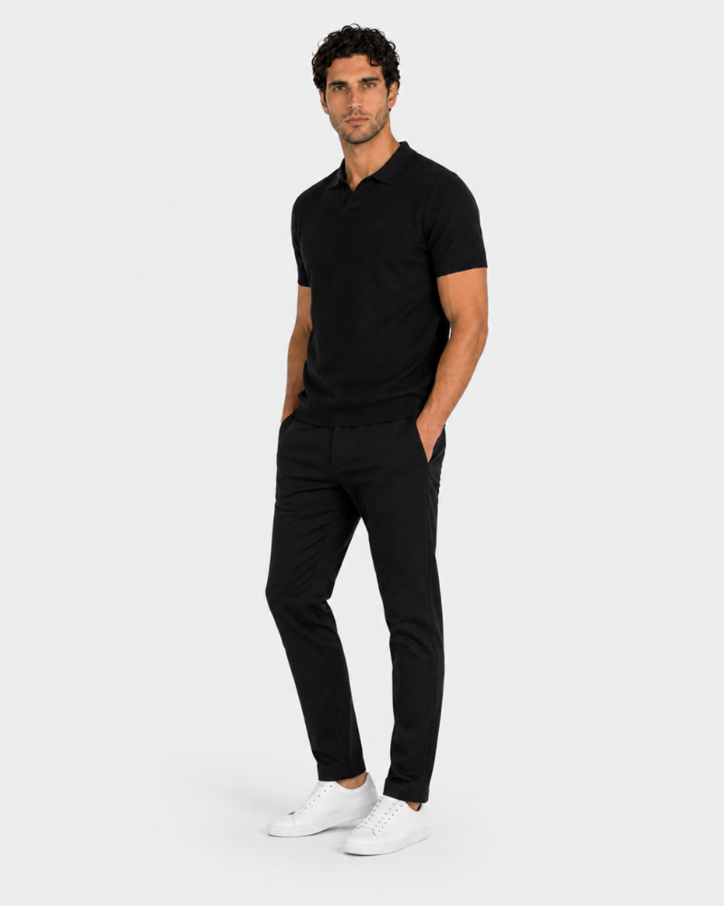 By Alden black open-collar knit polo shirt on male model, three-quarter view, full body, light gray background. #color_black