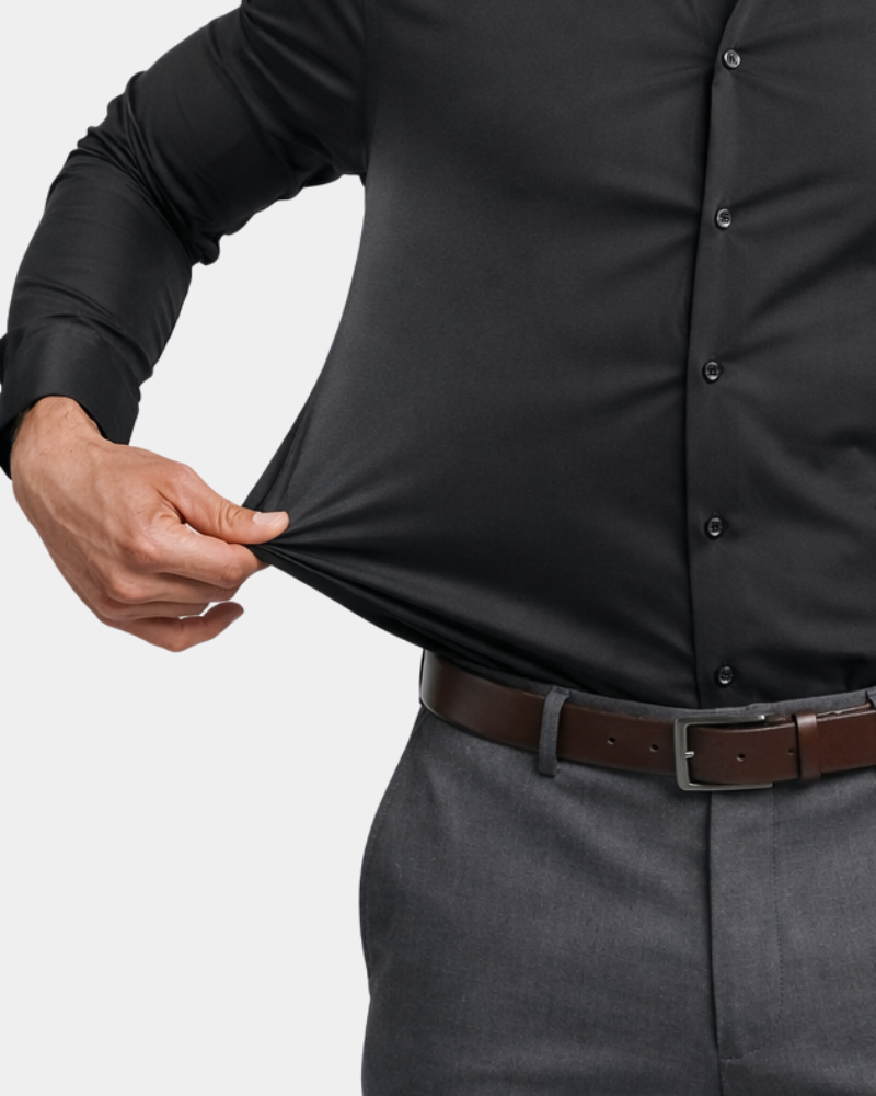 By Alden black stretch dress shirt fabric detail, male model pulling fabric, front close-up, light gray background. #color_black