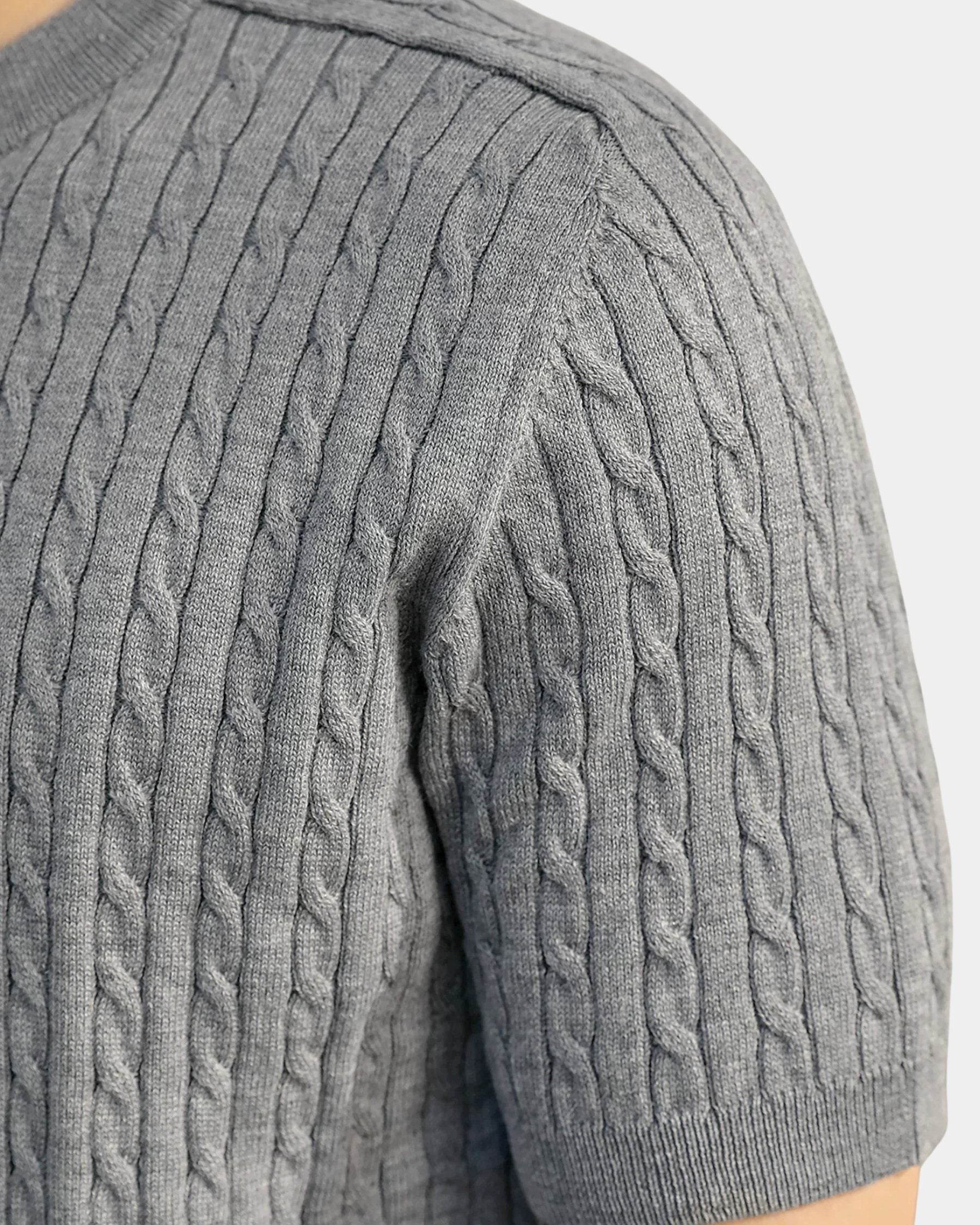 By Alden gray cable-knit short-sleeve sweater, close-up detail of shoulder and knit texture, light gray background #color_gray