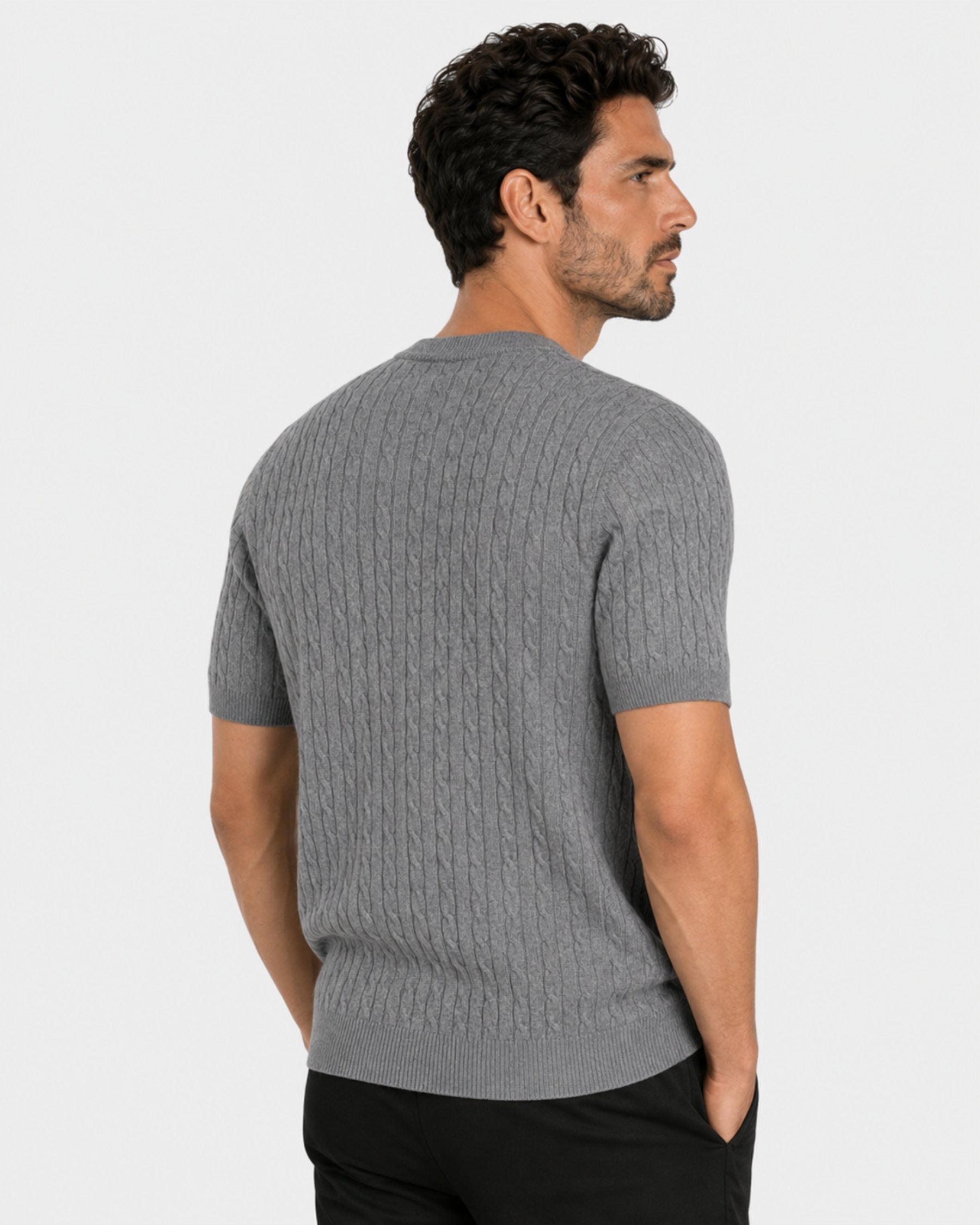 By Alden gray cable-knit short-sleeve sweater on male model, back view upper body, light gray background #color_gray