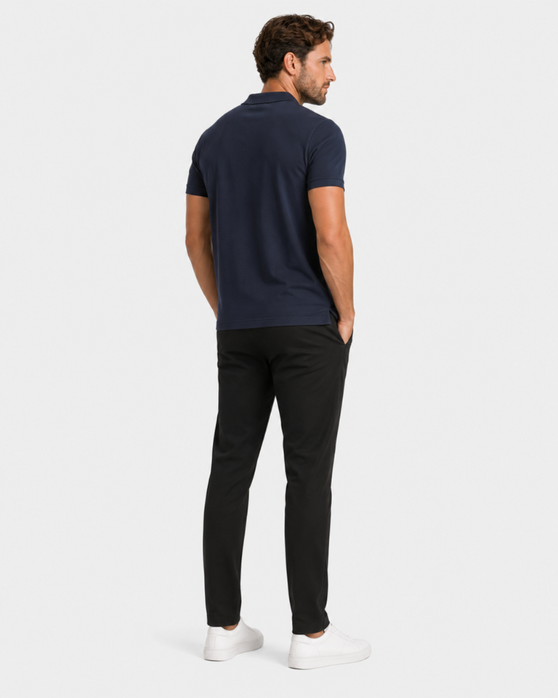 By Alden navy blue knit polo shirt on male model, back view, full body, light gray background. #color_navy