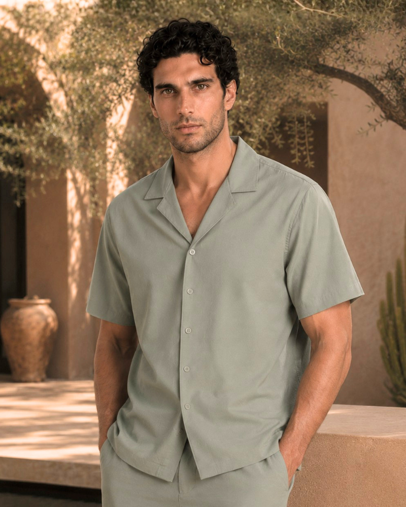 By Alden sage green short-sleeve camp collar shirt on male model, front view, upper body, outdoor beige background.
#Color_olive green