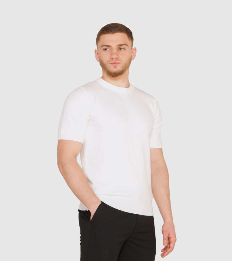 Man wearing a white t-shirt and black pants on a plain background